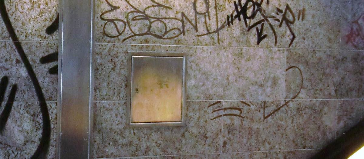 Graffiti auf einer Natursteinfassade vor der Reinigung